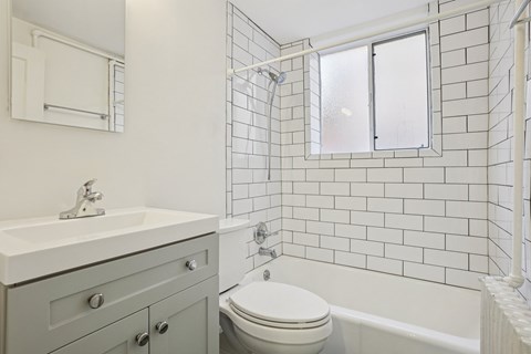 A white bathroom with a toilet, sink, and bathtub.