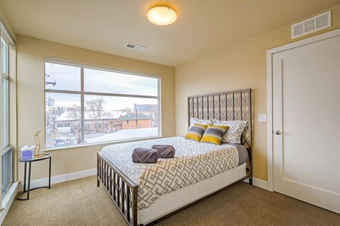a bedroom with a bed and a large window
