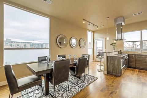 a dining room with a table and chairs next to a window