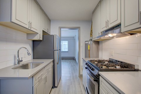 a kitchen with white cabinets and stainless steel appliances