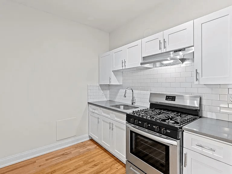 a kitchen with white cabinets and a stove top oven
