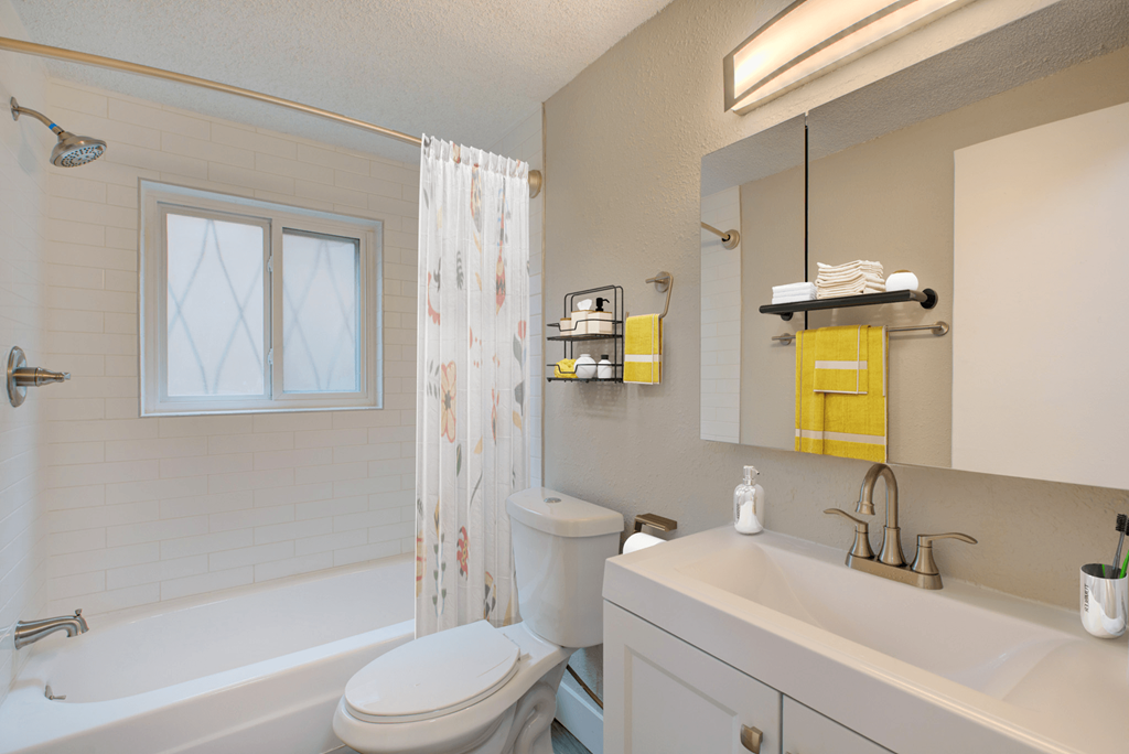 A white toilet sits next to a bathtub in a bathroom.