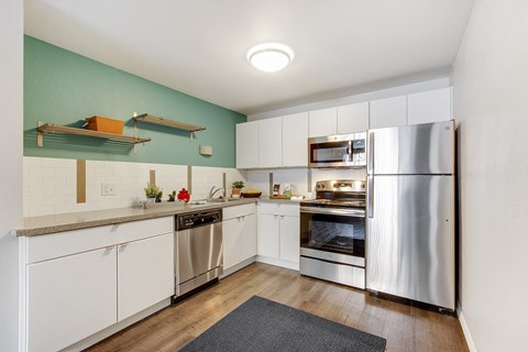 a kitchen with white cabinets and stainless steel appliances