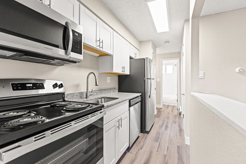 a kitchen with white cabinets and a stove and a refrigerator