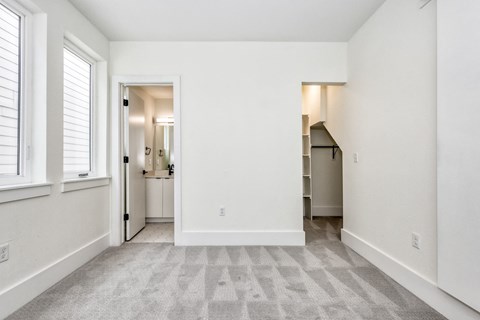 the living room of an apartment with white walls and a carpeted floor