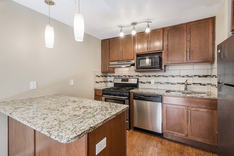 A kitchen with wooden cabinets and granite countertops.