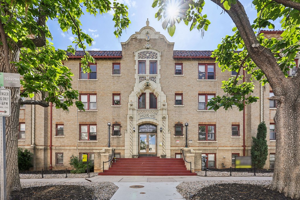 A large, historic-looking building with a red staircase leading to the entrance.