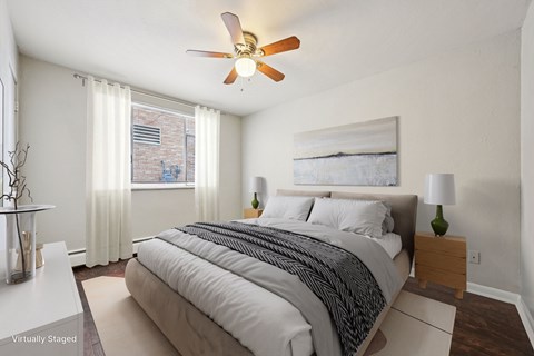 A bedroom with a large bed and a ceiling fan.