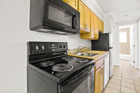 a kitchen with a stove and a microwave and a sink