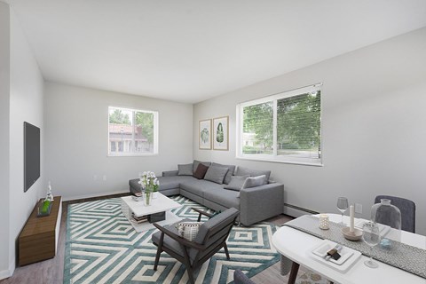 A living room with a grey couch and a white coffee table.