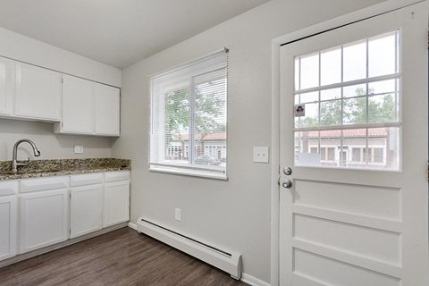 A kitchen with white cabinets and a granite countertop.