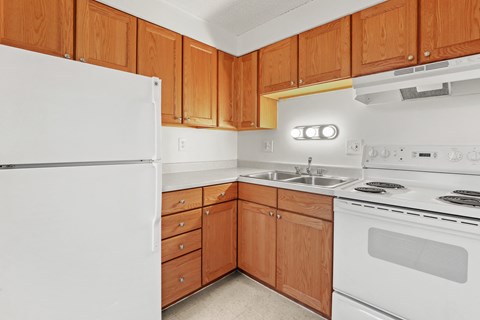 a kitchen with white appliances and wooden cabinets