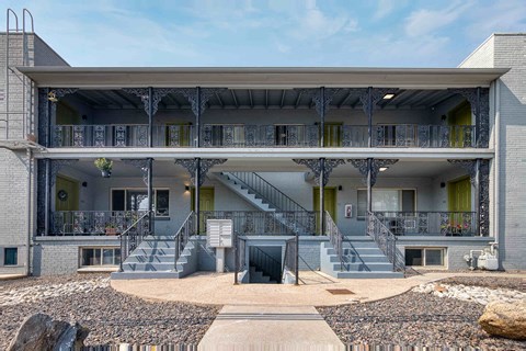 the exterior of a building with stairs and a porch