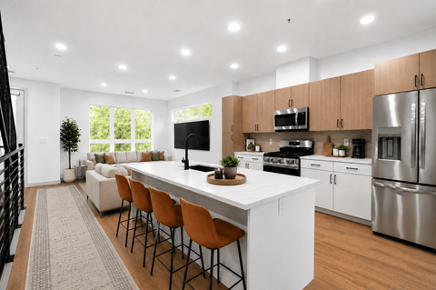 A modern kitchen with a white island and stainless steel appliances.
