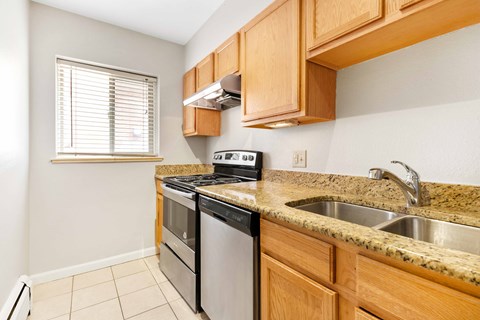 the kitchen has granite counter tops and stainless steel appliances and wooden cabinets