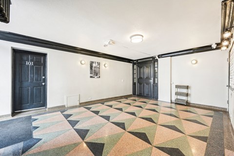 the interior of a room with black doors and a geometric rug