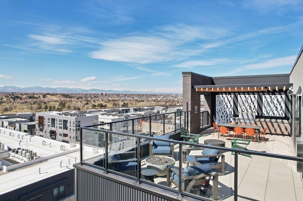 A modern building with a glass balcony overlooking a cityscape.