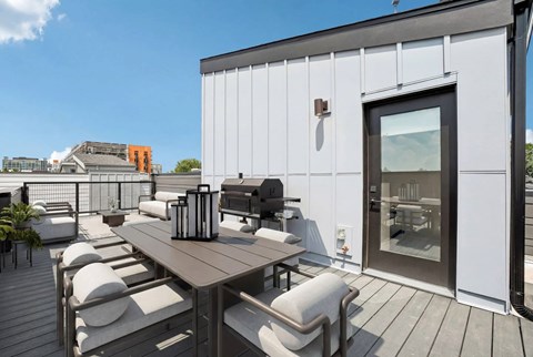 A modern outdoor dining area with a table and chairs.