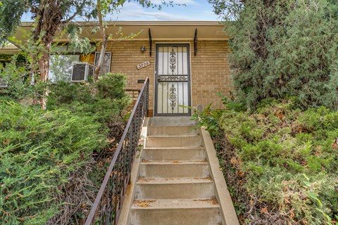 A house with a staircase leading to the front door.