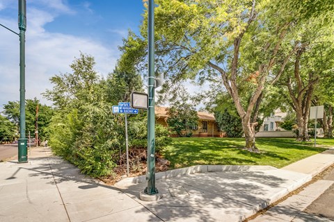 A street view with a blue sign and a green pole.