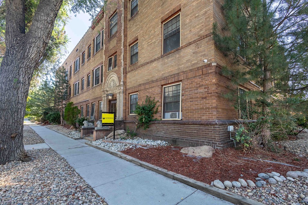 an old brick building with a sidewalk in front of it