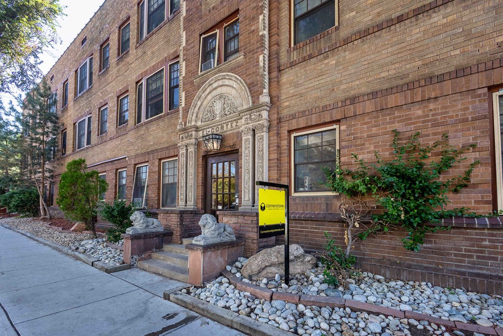 the front of a brick building with a yellow sign in front