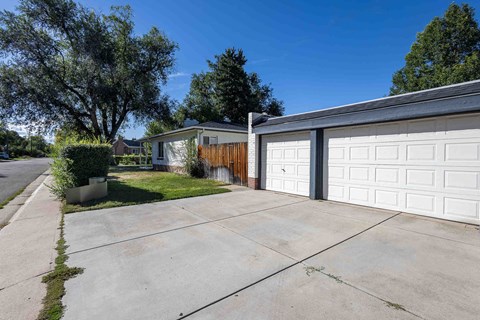 a white garage door and a driveway in front of a house
