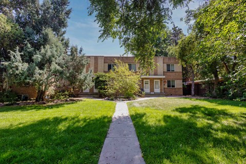a large brick building with a grassy yard in front of it