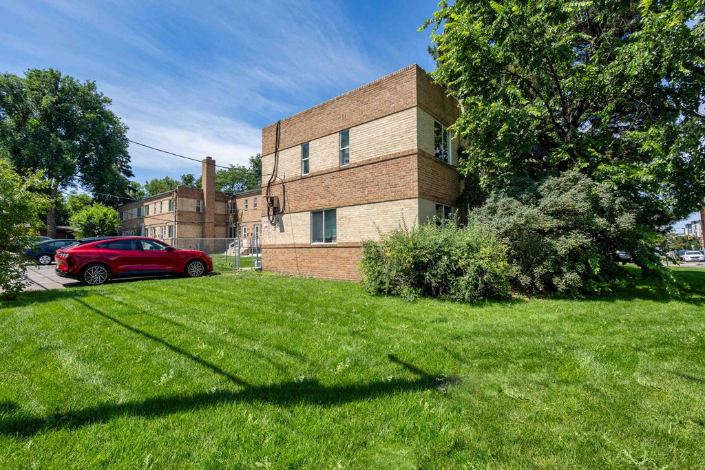 a brick building with a red car parked in front of it