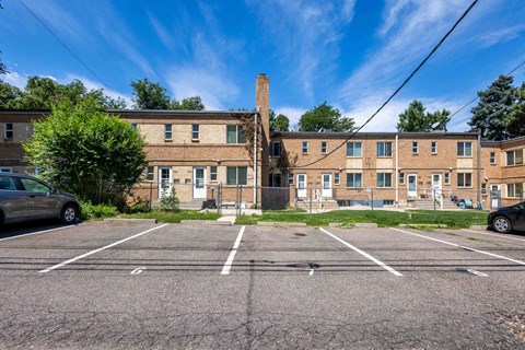 a large brick building with a chimney in the middle of a parking lot