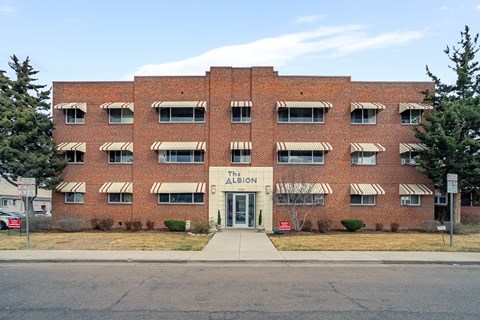 The front of a red brick building with awnings and a sign that says "The Abbey".