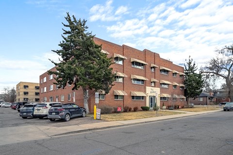 A parking lot with cars and a building in the background.