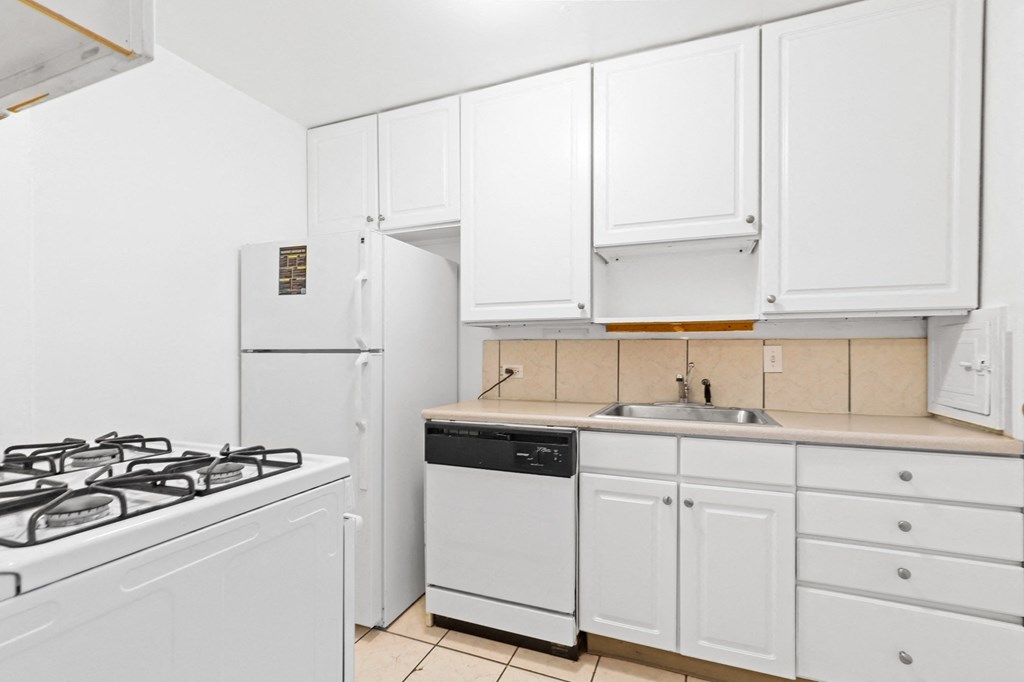 a kitchen with white cabinets and white appliances
