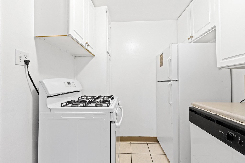 a kitchen with white appliances and white cabinets
