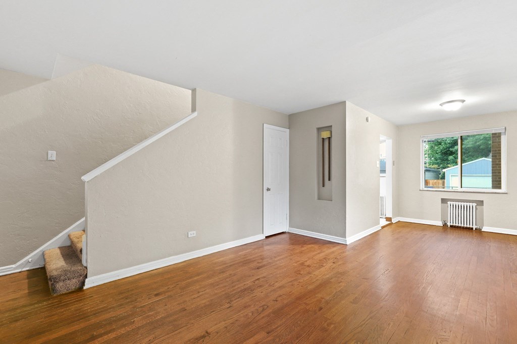 a living room with hardwood floors and white walls