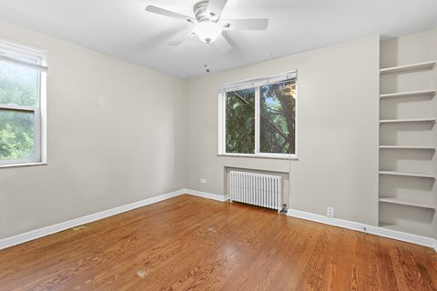 a bedroom with hardwood floors and a ceiling fan