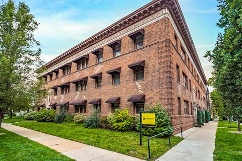 A large red brick building with a yellow sign in front.