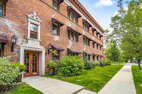 A red brick building with a brown door and windows.
