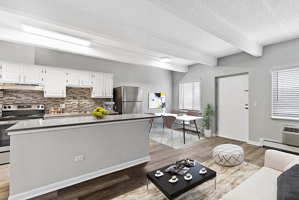 A modern kitchen with a stone backsplash and a dining area with a table and chairs.