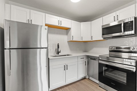 a kitchen with stainless steel appliances and white cabinets