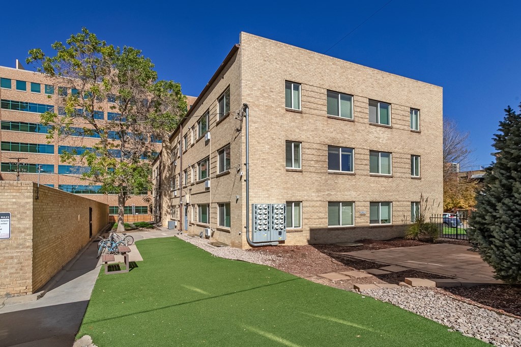 A building with a green lawn in front.