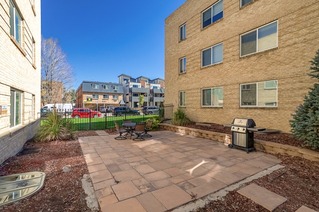 A courtyard with a bench and a trash can.