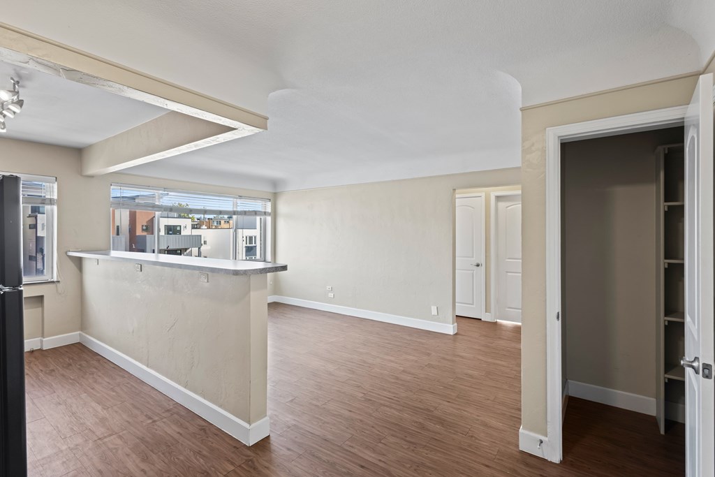 A room with a bar area and a view of the outside.