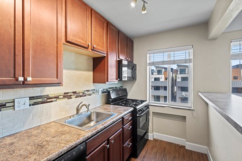 A kitchen with brown cabinets and a black stove top oven.