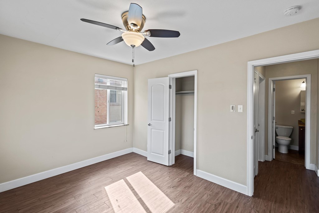 A room with a ceiling fan and a window.