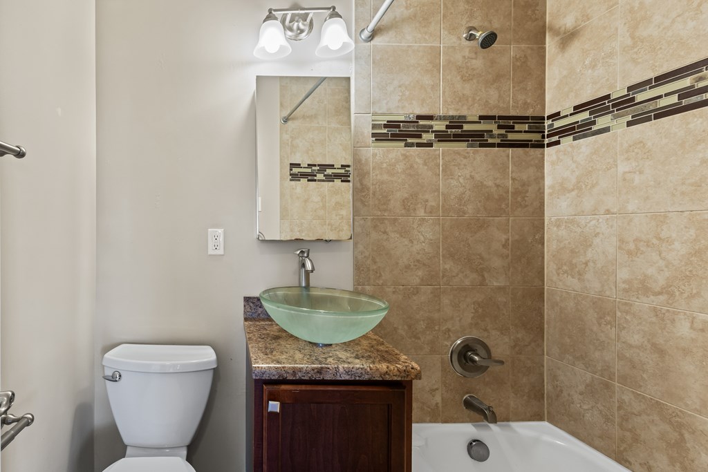 A bathroom with a toilet, sink, and shower.