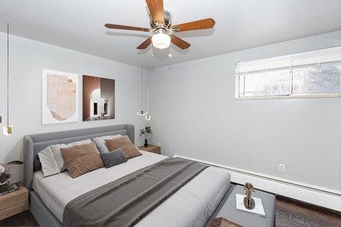 a bedroom with a large bed and a ceiling fan