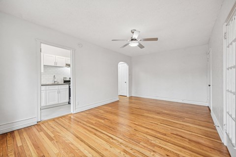 A room with wooden floors and a ceiling fan.