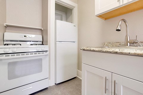 a kitchen with a stove refrigerator and sink