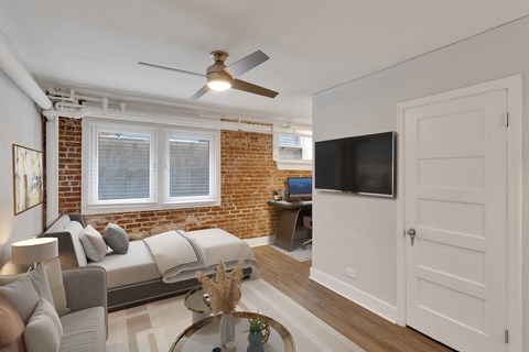 A living room with a brick wall and a couch.